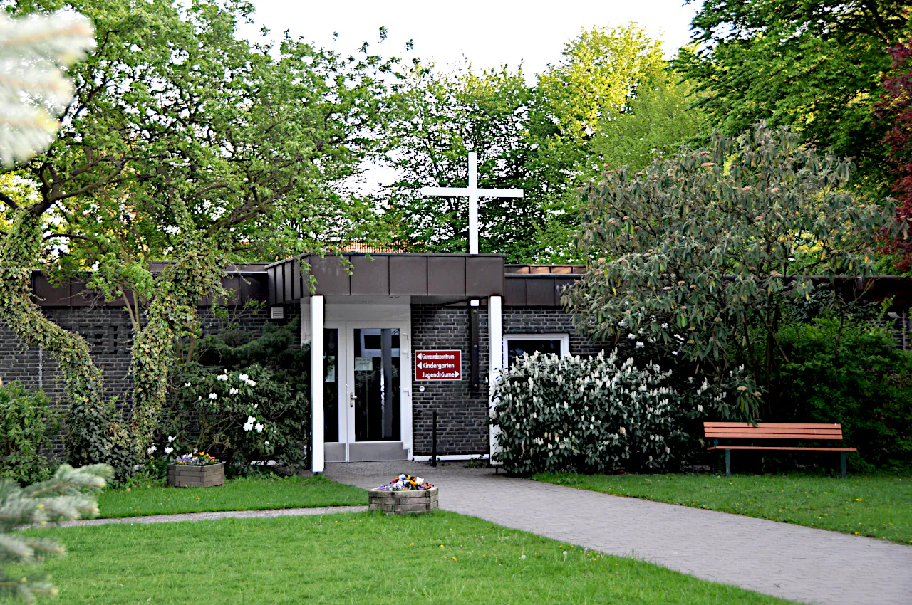 Ein Foto des Eingangs zur Emmaus Gemeinde mit einem Kreuz über der Tür